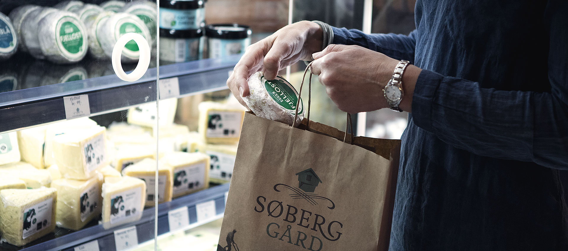 Dame som handler ost på gårdsbutikken til Søberg Gård i Alvdal